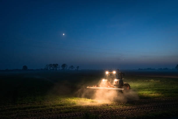 istock Evening with a tractor in a field with a crescent moon 1921094035
