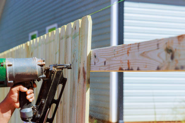 Man builds sections of nailing a wooden fence around his yard out planks Man builds sections of nailing a wooden fence around his yard out planks using air nail gun rough hands man stock pictures, royalty-free photos & images
