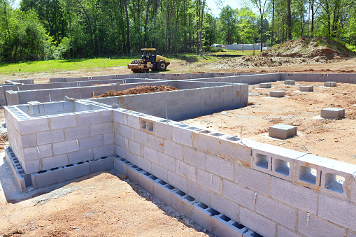 On construction site, cement blocks have been installed as foundation for walls of house