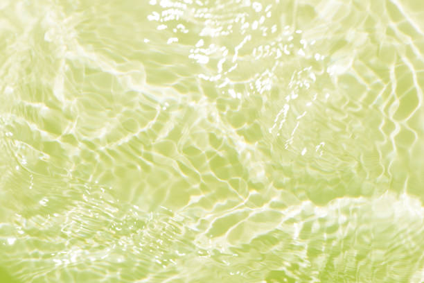 istock Green water waves on the surface ripple blurred. Defocus blurred transparent blue colored clear calm water surface texture with splash and bubbles. Water waves with shining pattern texture background. 1921116559