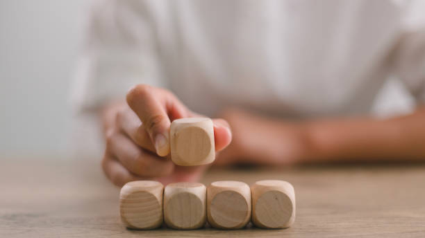 istock Businesswomen stack blank wooden cubes on the table with copy space, empty wooden cubes for input wording, and an infographic icon. 1921130063