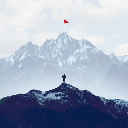 Business success goals and challenges as climbing a high mountain metaphor as a businessman with a goal of retreiving a red flag from the peak or summit with 3D illustration elements.