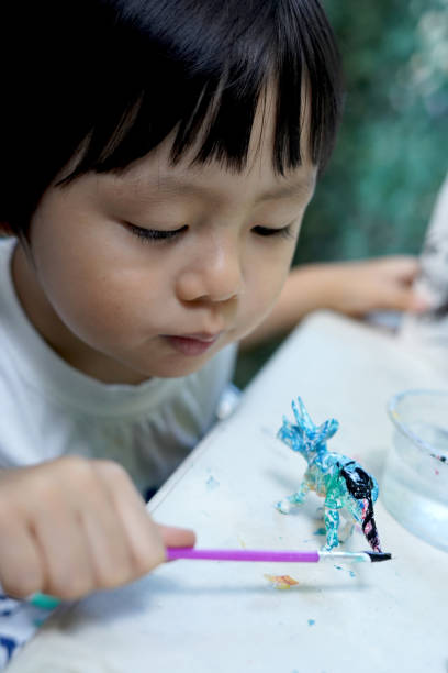 Child coloring with paints