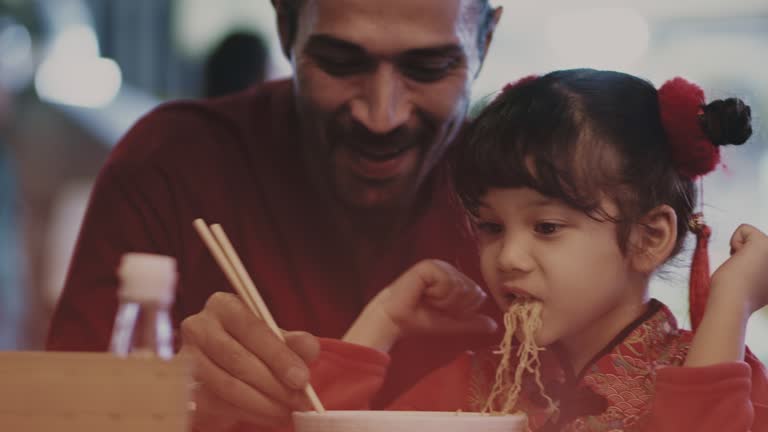 Father and daughter enjoying noodles together