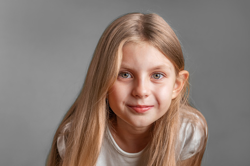 Female portrait of charming child of three years with a beautiful smile, cheerful shot on isolated pink.