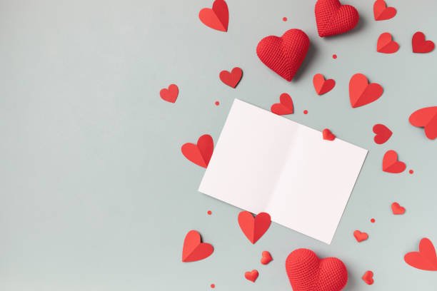 istock Valentine day festive composition with empty paper card and red hearts on pastel blue background top view. 1921344904