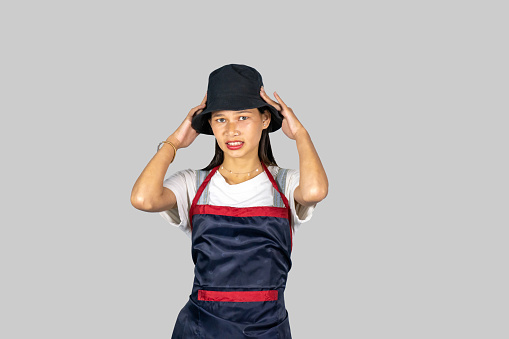 An Asian Indian Farmer Nepalese Girl in an apron giving several gestures and expressions of happiness, saddness, pointing etc.