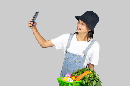 Excited and Happy Farmer Girl with Fruits and vegetables selling from mobile phone giving gestures