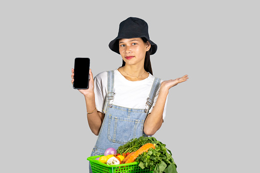 Excited and Happy Farmer Girl with Fruits and vegetables selling from mobile phone giving gestures