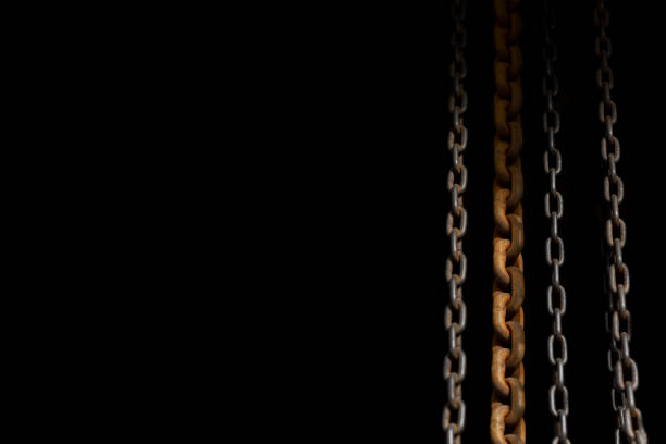 grupo de cadena oxidada vieja con poca luz y fondo negro - fotos de ahorcamiento fotografías e imágenes de stock