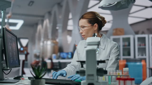 Biochemistry specialist checking samples in beaker working in laboratory closeup