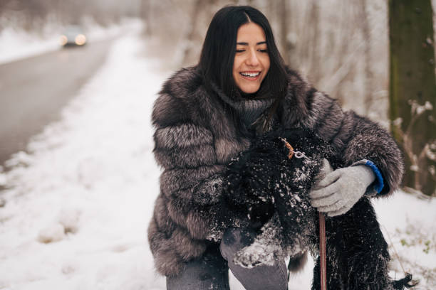 young woman with her dog outside in the snow