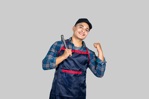 Young Male Asian Farmer with Agricultural Tools wearing an apron in Nepal giving gestures and expressions