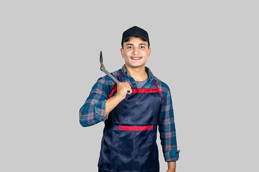 Young Male Asian Farmer with Agricultural Tools wearing an apron in Nepal giving gestures and expressions