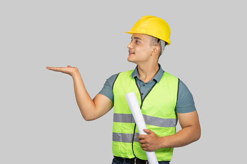 An Asian Happy Construction Worker Engineer giving expression gestures with chartpaper and notebook