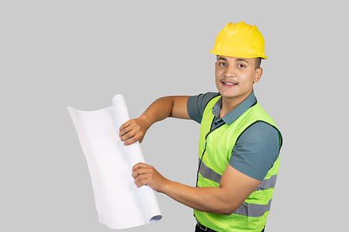 An Asian Happy Construction Worker Engineer giving expression gestures with chartpaper and notebook