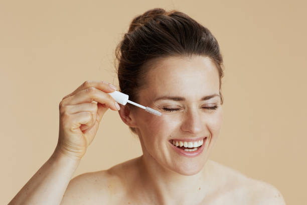 istock woman with brow brush isolated on beige 1921446406
