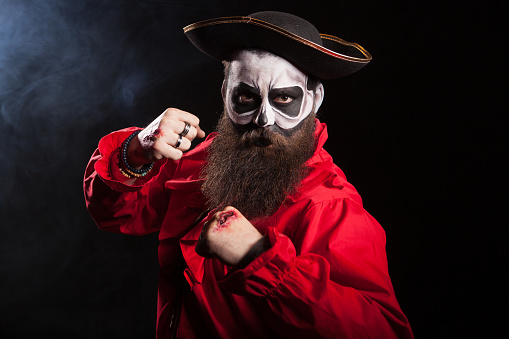 Scary pirate with fists up isolated over black background.Spooky man.