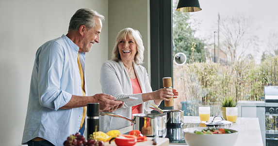 Elderly, couple and cooking in kitchen with tablet for meal prep, recipe idea and digital menu and happy. Senior, man and woman with technology at home for healthy food ingredients and diet planning