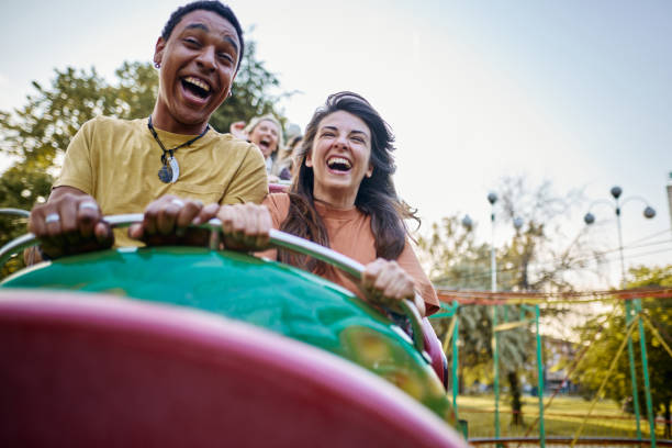 istock Cheerful couple having fun while riding on rollercoaster at amusement park. 1921539623