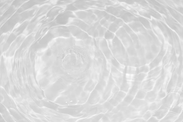 istock White water with ripples on the surface. Defocus blurred transparent white colored clear calm water surface texture with splashes and bubbles. Water waves with shining pattern texture background. 1921543279