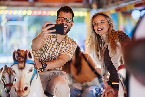 Teenagers ride head down on a carousel. Extreme rides in the park.