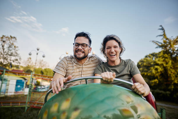 istock Young happy couple having fun on rollercoaster at amusement park. 1921554401