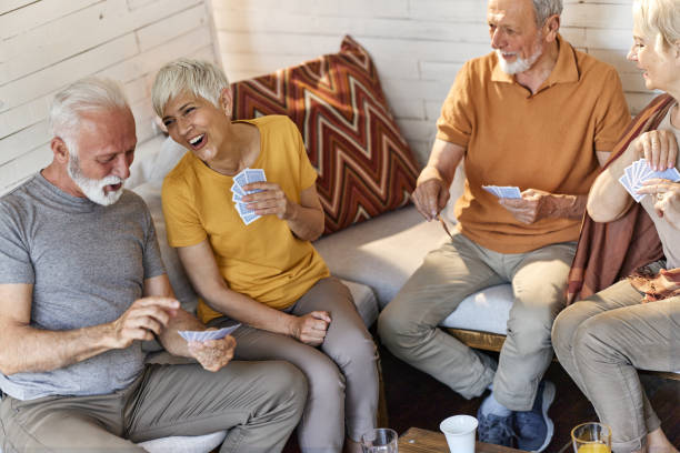 istock Cheerful mature couples enjoying while playing cards at home. 1921556522