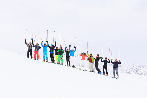 Skiing and Snowboarding  club. Big Group of  skier and  snowboarder, friends male and female on the top of mountain ski slope. Europe Alps. Italy ski resort Livignio