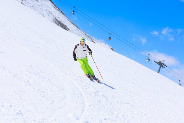 vital senior,  men snow skier skiing, enjoying on sunny ski resorts. skiing carving at high speed against blue sky. - skiing point of view foto e immagini stock