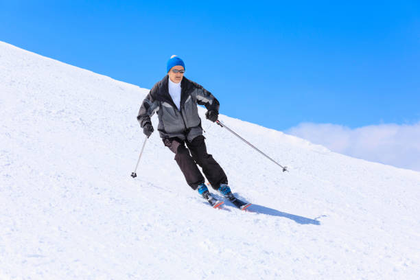 vital senior,  men snow skier skiing, enjoying on sunny ski resorts. skiing carving at high speed against blue sky. - skiing point of view zdjęcia i obrazy z banku zdjęć