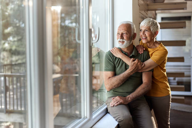 istock Senior couple in love looking through their home window. 1921572356