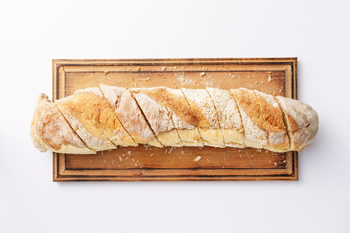 homemade baguette on wooden board closeup, olive italian bread, isolated on white