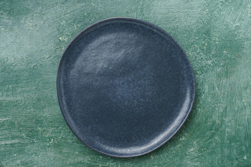 Empty vintage plate on green rustic table