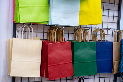 Gifting bags for sale can be reusable in red,white,blue and green colors presented on shopping hangers to be sold