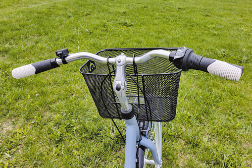 Front view of a bicycle with a hanging bag in the meadow, view from above