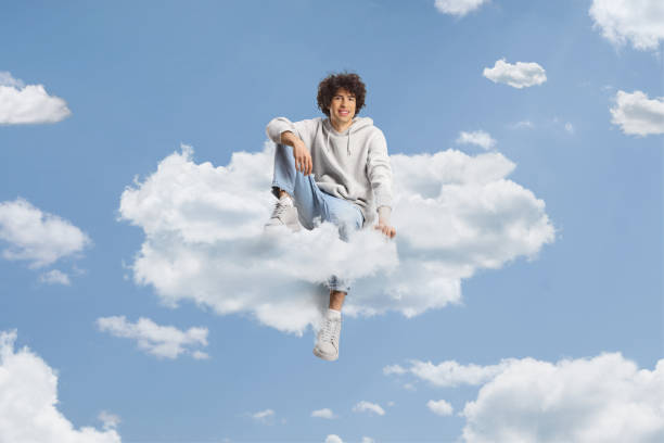 istock Guy with curly hair sitting on a cloud and smiling 1921676288