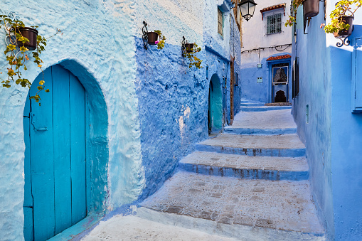 Street with old wooden blue door in Chefchaouen, Morocco, Africa.