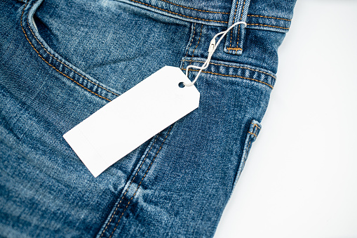 Denim jeans and blank clothing tag. Template for tag or label design