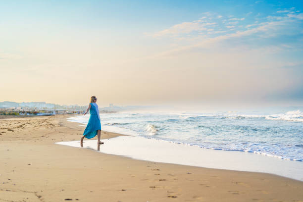 istock Beautiful woman walking on beach 1921695099