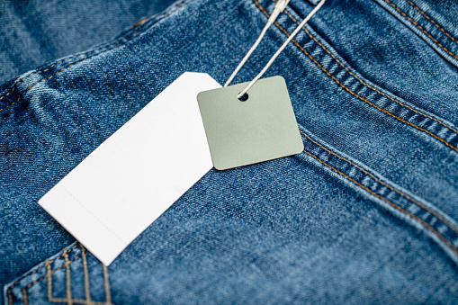 Blank clothing tag on new denim pants. Template for tag or label design