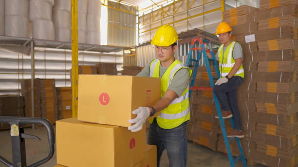 Group of Latin American workers loading a truck with boxes at a distribution warehouse - freight transportation concepts