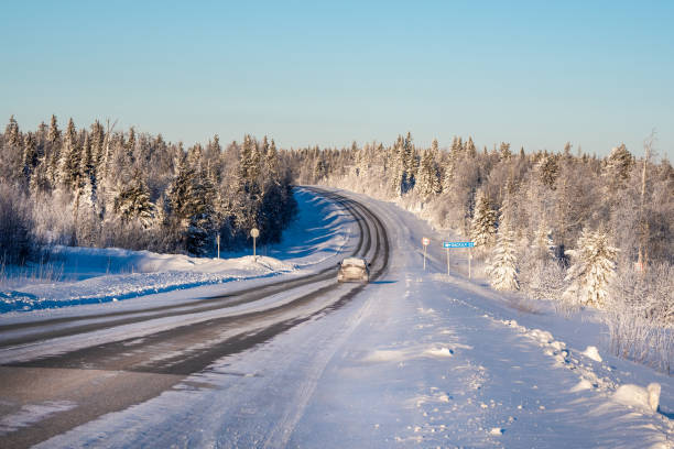 istock Frosty sunny winter snow-covered highway through hills covered with snowy coniferous forest. 1921714137