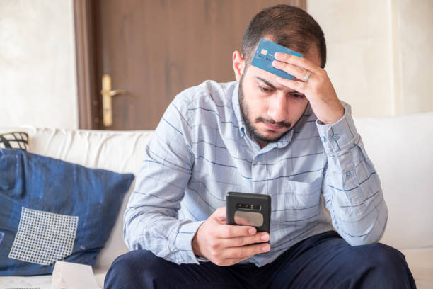 istock male holding bank card while feeling stressed due to financial issue 1921717296