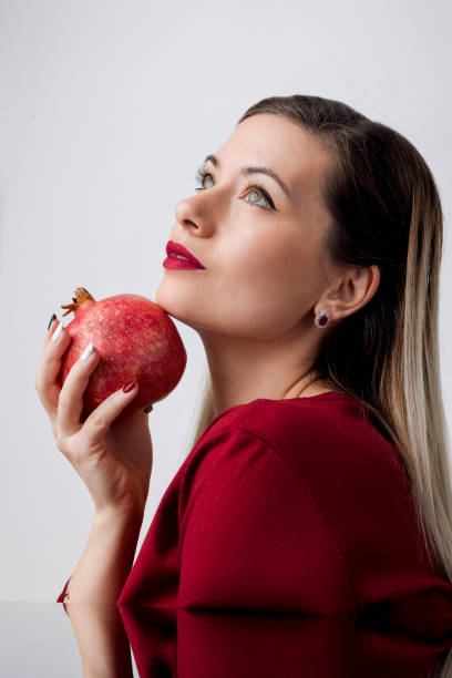 istock Beautiful Blonde with Red Lipstick and Pomegran Creative Makeup - Studio Concept on White Background 1921794598