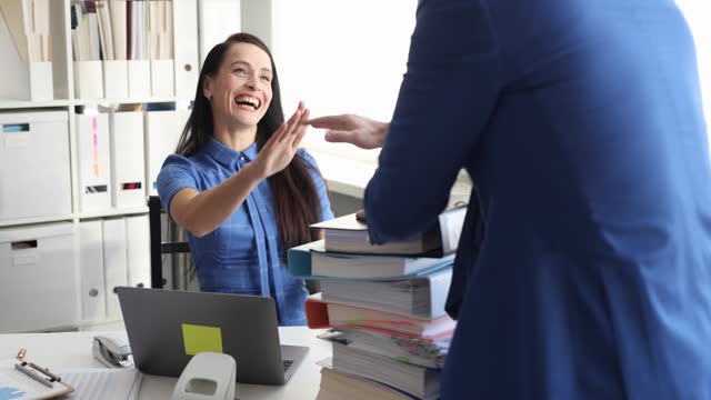Manager brings many folders to young woman secretary to work with documents slow motion 4k movie