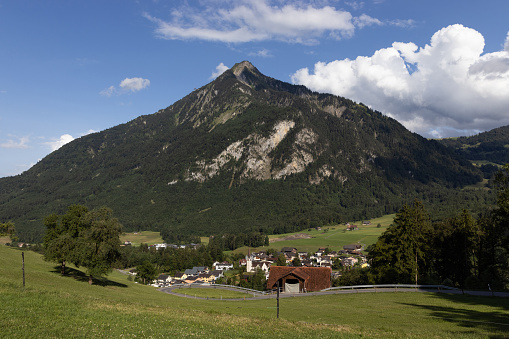 View towards the village of Ennetmoos, with Stanserhorn mountain towering behind, in Nidwalden, Switzerland. Green landscape view in the summer. Copy space above.