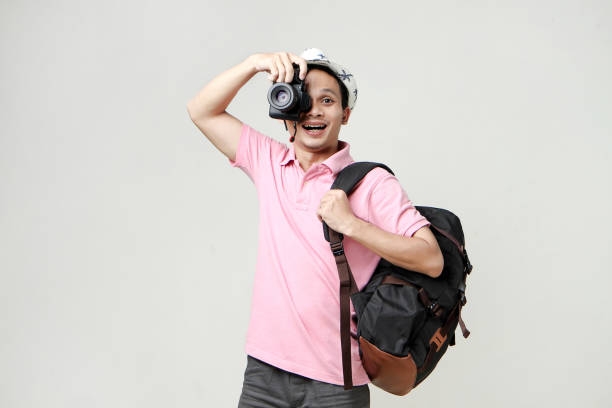 istock Asian man backpacker taking photo with digital camera. travelling concept. on isolated background 1921855120