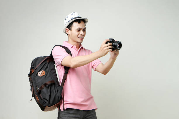 Man Looking Through Lens Against Wall