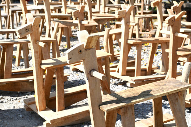 A white, blue and red wooden children's playground horse mounted on a large steel spring